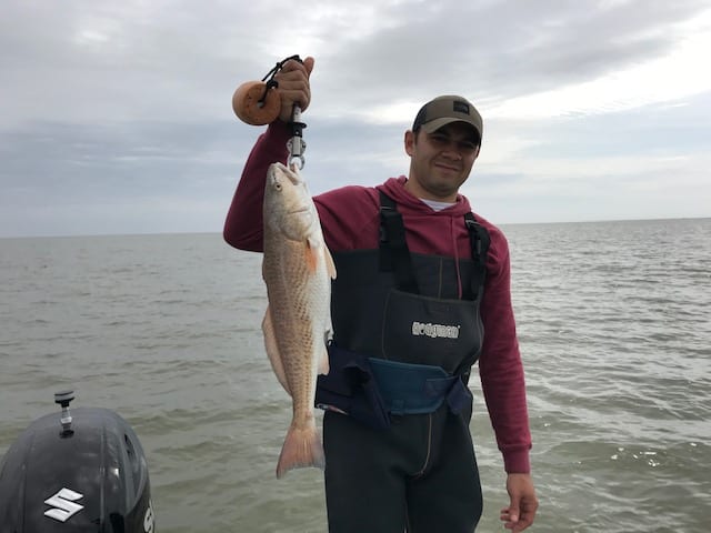 A Man Holding a Medium Size Red Fish